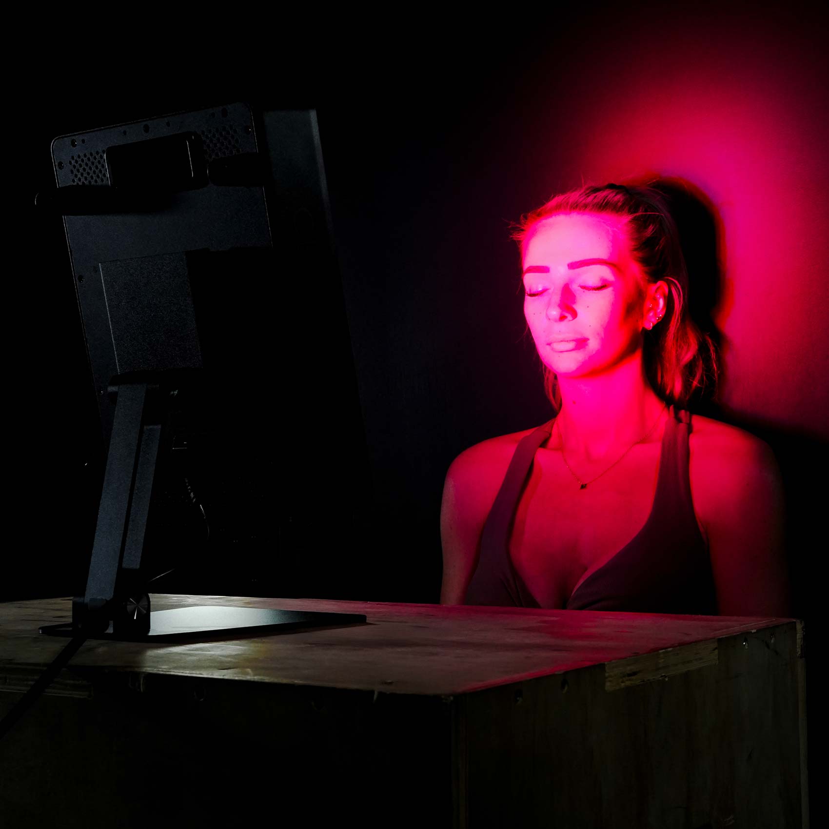 Sat in front of red light panel