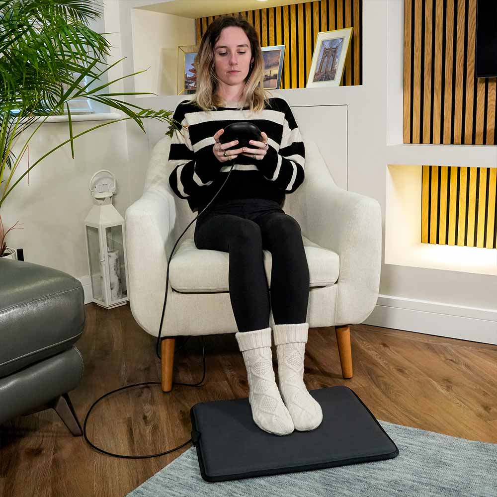 Sat applying mini mat to feet